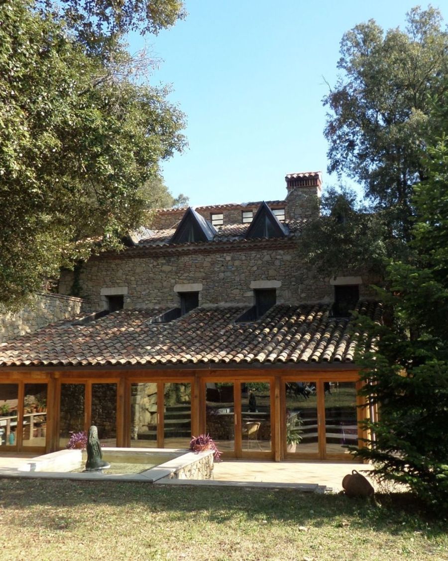 Casa de piedra rodeada de árboles